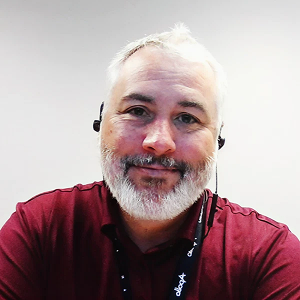 Andy Bennett, CTO and CISO of Apollo Information Systems, smiling in a red shirt with a headset.